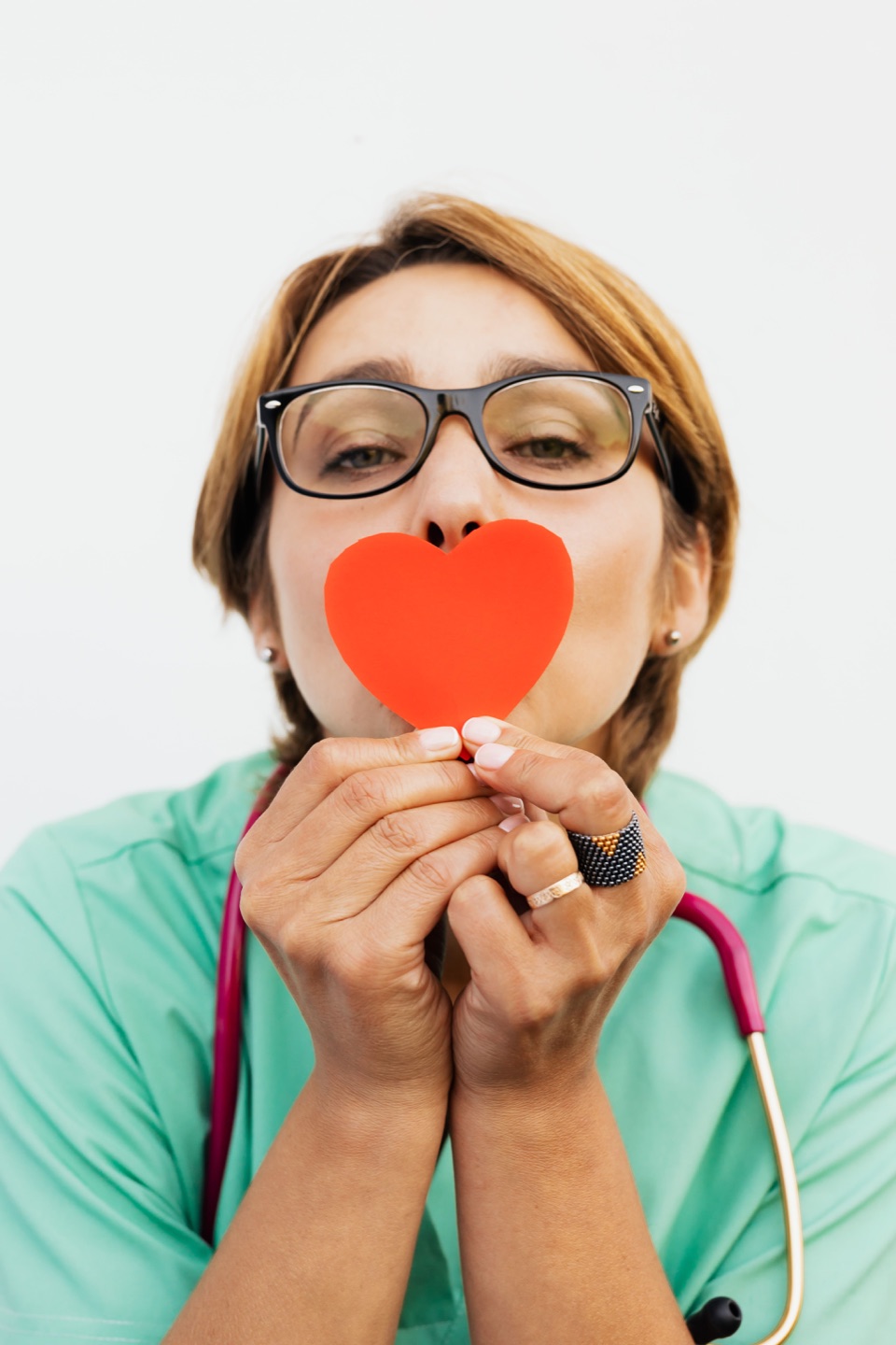 Healthcare professional holding a red paper heart