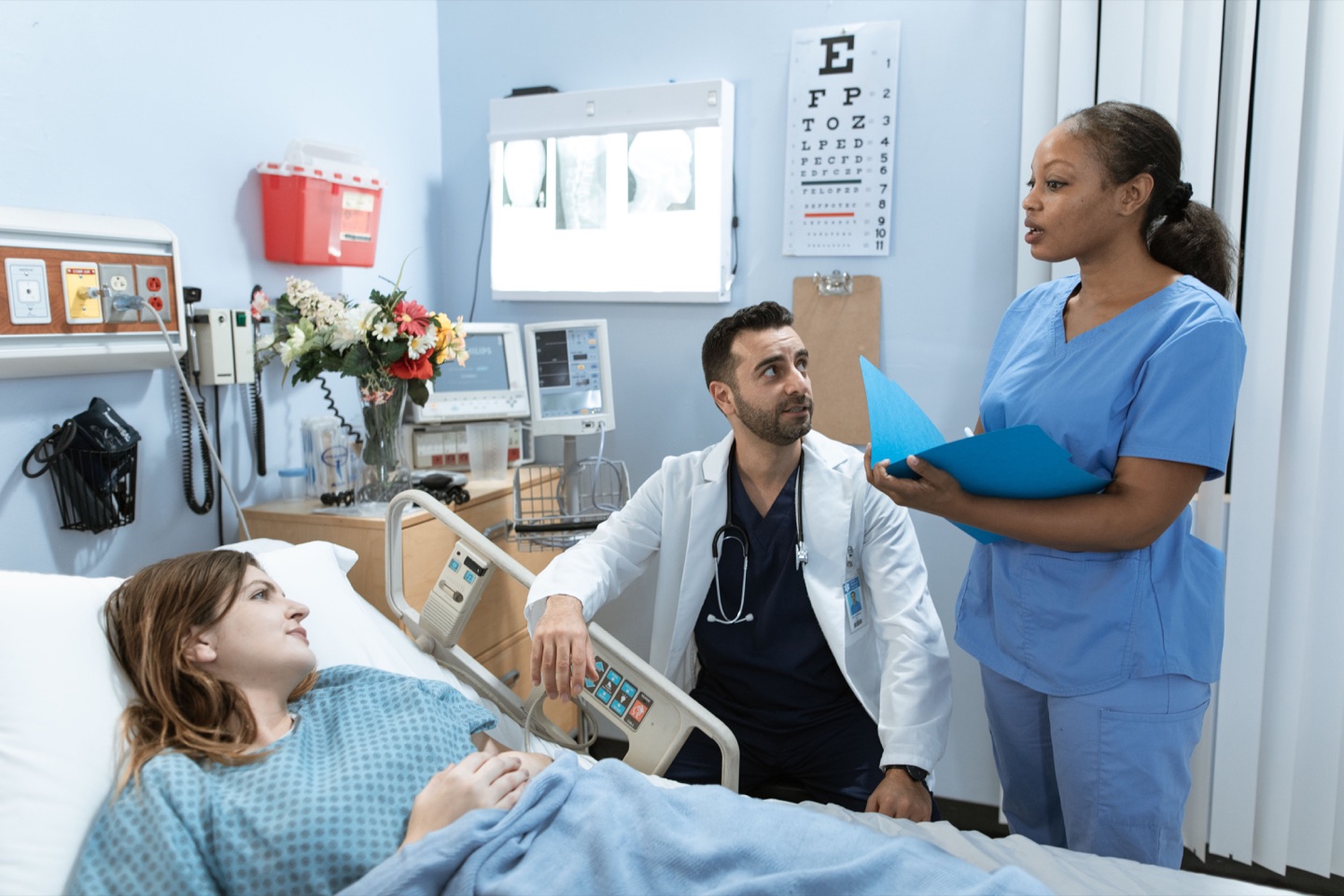 Healthcare professionals discussing bedside care with a patient